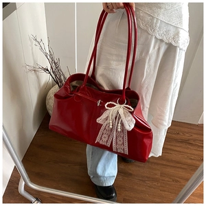 Detailed shot of red patent leather tote with white lace pearl bow charm decoration