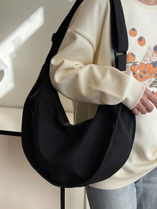 Minimalist black crescent crossbody bag with wide strap for casual daily use