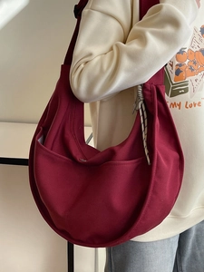 Minimalist burgundy canvas hobo bag in half-moon shape with wide adjustable shoulder strap