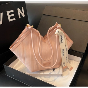 Detail of light pink tote bag with wavy texture and silk ribbon in black gift box
