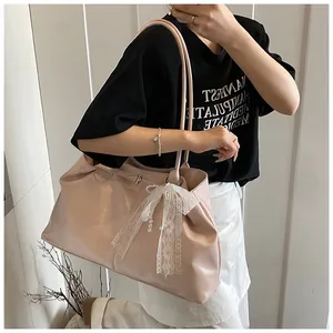 Close-up of pink tote bag featuring white lace bow and elegant pearl charm detail