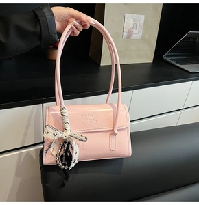 Sac à bandoulière en cuir rose brillant avec nœud en dentelle et breloque perle