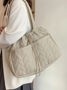 Minimalist beige quilted tote bag with drawstring closure and soft shoulder strap