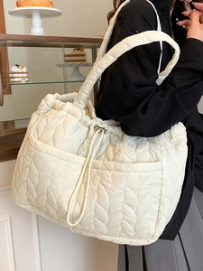 Minimalist creamy white quilted tote bag with leaf pattern stitching and drawstring closure