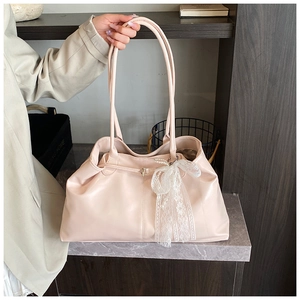 Close-up of pink tote bag featuring elegant white lace bow and delicate pearl pendant