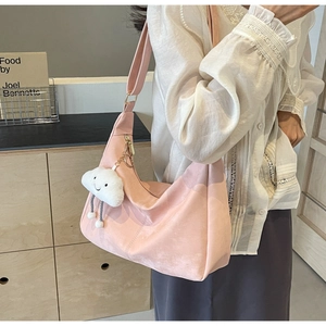 Close-up of pink soft leather tote bag featuring a cute white cloud plush pendant