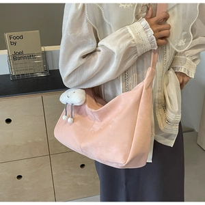 Detail view of pink soft leather tote bag with a white fluffy cloud pendant and crossbody strap