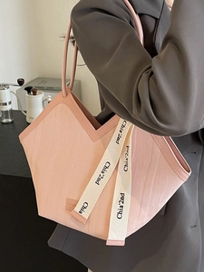 Pink large capacity tote bag with wave texture and contrast ribbon on grey blazer