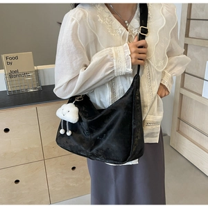 Close-up of black velvet crescent hobo bag with a white cloud plush charm detail
