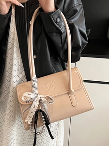 Sac sous le bras minimaliste en cuir verni beige avec noeud en dentelle et chaîne