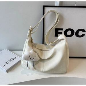 Detail view of cream soft leather hobo bag with cute cloud charm and adjustable strap