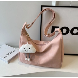Pink suede dumpling bag with a cute white cloud plush pendant and adjustable strap detail