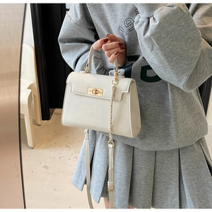 Detail of cream crossbody bag with textured leather, gold twist lock and chain strap