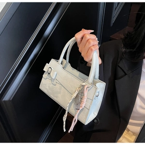 Dettaglio della borsa in pelle azzurra con fiocco elegante e ornamento in corda intrecciata