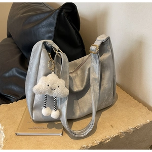 Detail of silver metallic hobo bag with wide strap and cute cloud plush charm