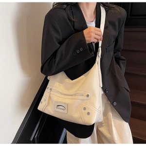 Détail du sac hobo en cuir PU crème avec rivets argentés et plaque en métal Noronoro