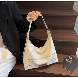 Gros plan sur le sac en similicuir blanc crème avec rivets argentés et fermetures éclair