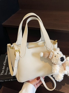 White lychee pattern bucket bag with golden hardware and cute plush charm pendant