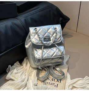 Detail of silver quilted mini backpack with chain handle and metallic turn-lock closure