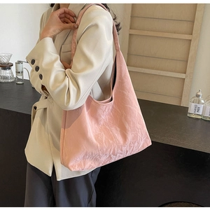 Detail view of pink wrinkled texture tote bag with a glossy finish on a shoulder strap