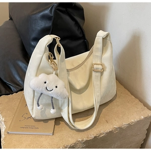 Detail of soft cream tote bag with gold buckle strap and cute cloud plush charm