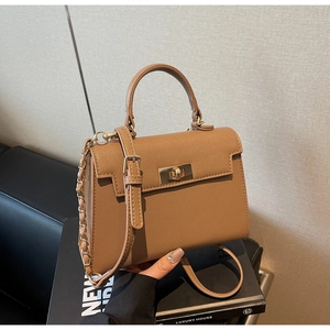 Close-up of the textured brown leather surface and gold metal turn-lock on the Kelly bag