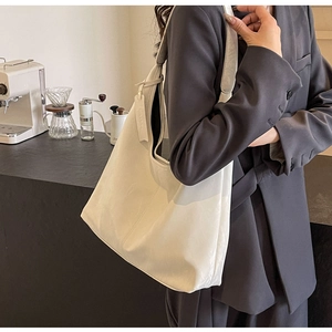 Detail of soft ivory leather tote bag shown in a professional urban office setting