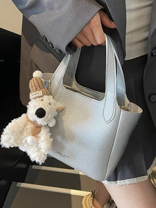 Silver lychee grain leather bucket bag with plush bear charm and handle for commuting