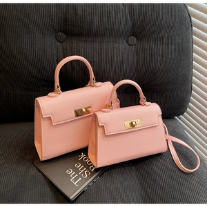 Detailed view of pink lychee grain leather Kelly style bags with golden metal twist locks