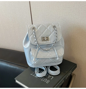 Detail of light blue quilted patent leather mini backpack with silver twist lock and chain