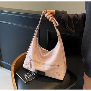 Détails du sac hobo en cuir mat rose avec des clous argentés et des fermetures éclair