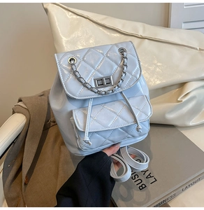 Detail of light blue quilted mini backpack featuring silver chain and metal twist lock