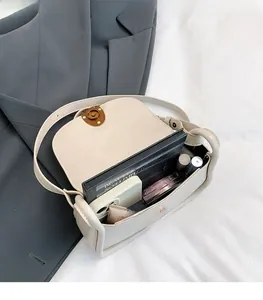 Detail view of the spacious cream saddle bag interior with vintage magnetic hardware