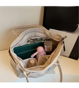 Interior view showing large capacity compartments of the beige canvas tote bag with zipper