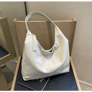 Detailed macro view of the marble texture on the cream white faux leather tote bag