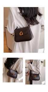 Detail of dark coffee saddle bag featuring a textured leather finish and gold horseshoe buckle