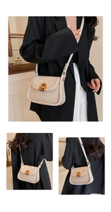 Close-up of retro saddle bag showing fine leather texture and golden arch metal buckle