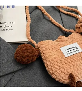 Detailed close-up of handmade crochet knitted shoulder bag with a soft woolen texture