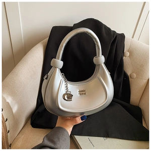 Dettaglio ravvicinato di una borsa a mezzaluna argento con finitura metallica e logo in metallo