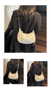 Détail du sac bandoulière demi-lune crème avec texture marbrée et bandoulière chaîne