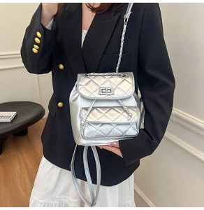 Silver quilted leather mini backpack with metal chain straps and twist-lock closure detail