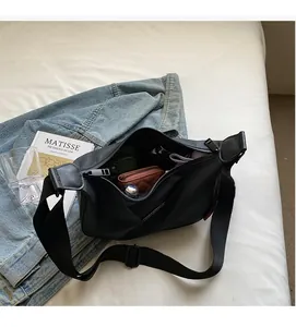 Spacious interior of black nylon crescent crossbody bag showing large storage capacity