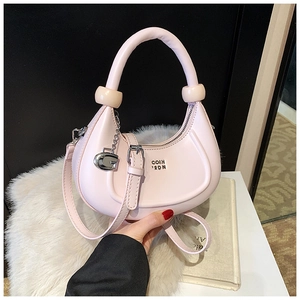 Dettaglio borsa a mezzaluna rosa con sfere color crema e ciondolo a G in metallo