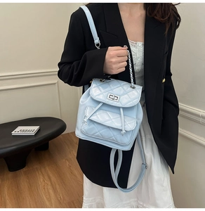 Light blue quilted leather mini backpack with silver chain detail on model