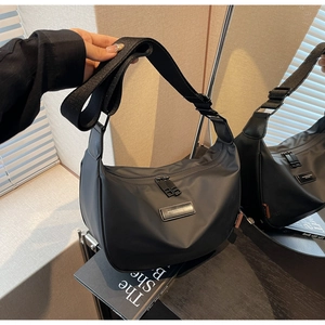 Detail of black nylon dumpling bag with adjustable wide strap and smooth dual zippers