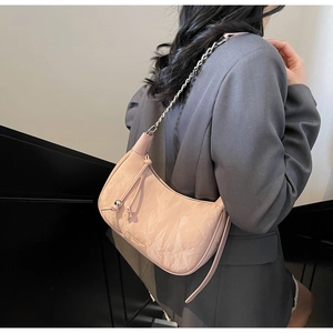 Détail du sac bandoulière rose en similicuir plissé avec chaîne et perles argentées