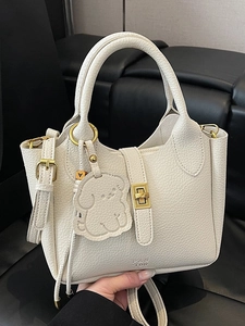 Sac seau chic en cuir blanc à motif litchi avec détails dorés et breloque chien