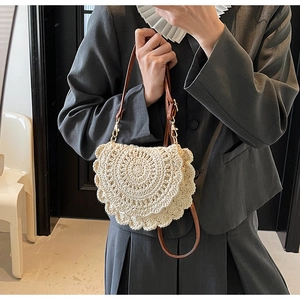 Détail d'un sac à bandoulière beige au crochet en demi-lune aux motifs ondulés