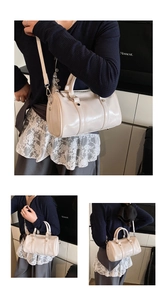 Detail view of cream Boston bag with smooth synthetic leather and silver hardware