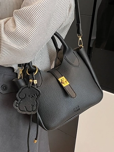 Sac seau élégant en cuir grainé noir avec détails dorés et breloque chiot chic